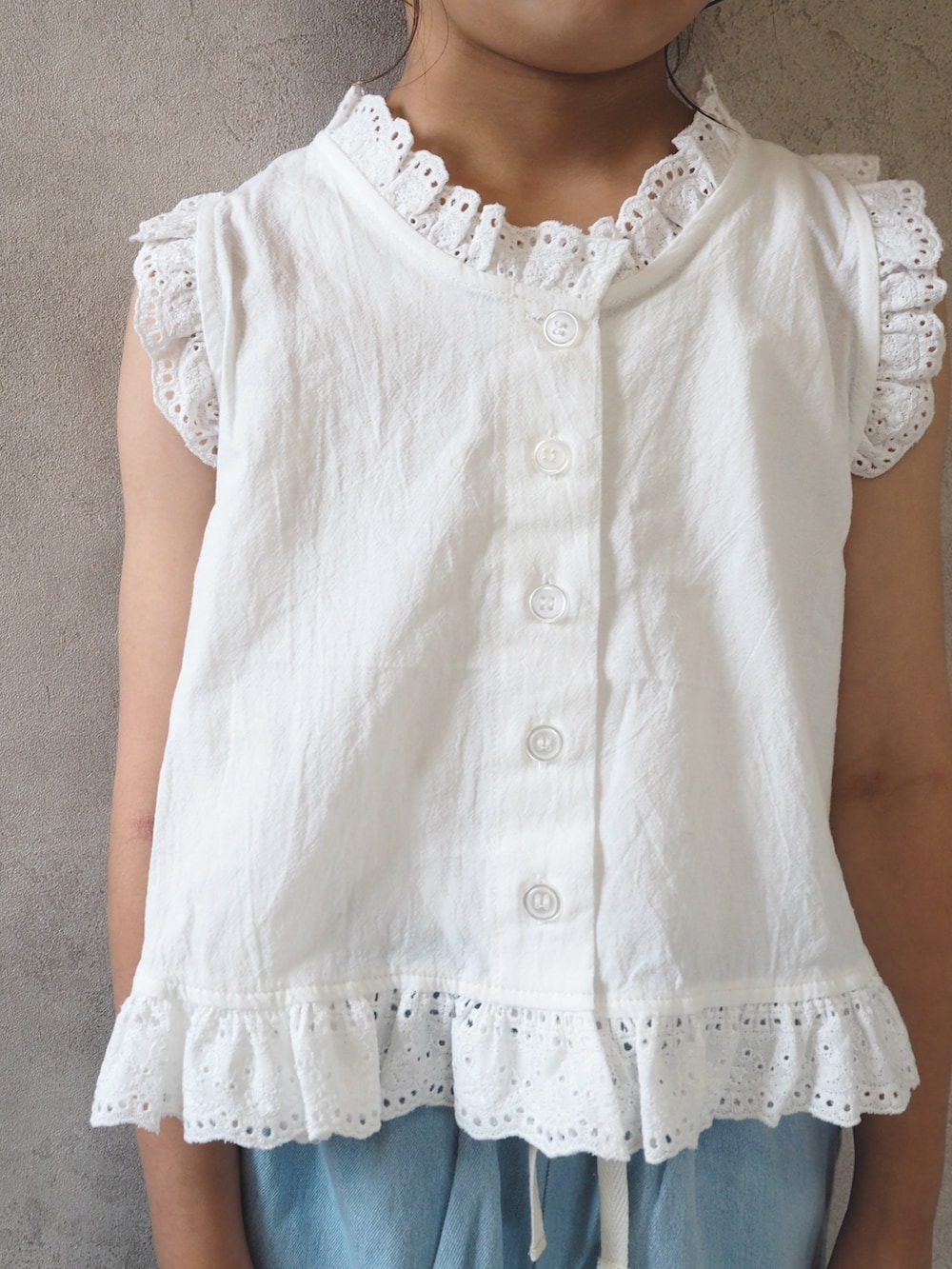 ブルー系のデニムパンツ、シルバー系のショルダーバッグ、ブラック系のサンダルを着用したキッズの夏コーディネートの4枚目の写真