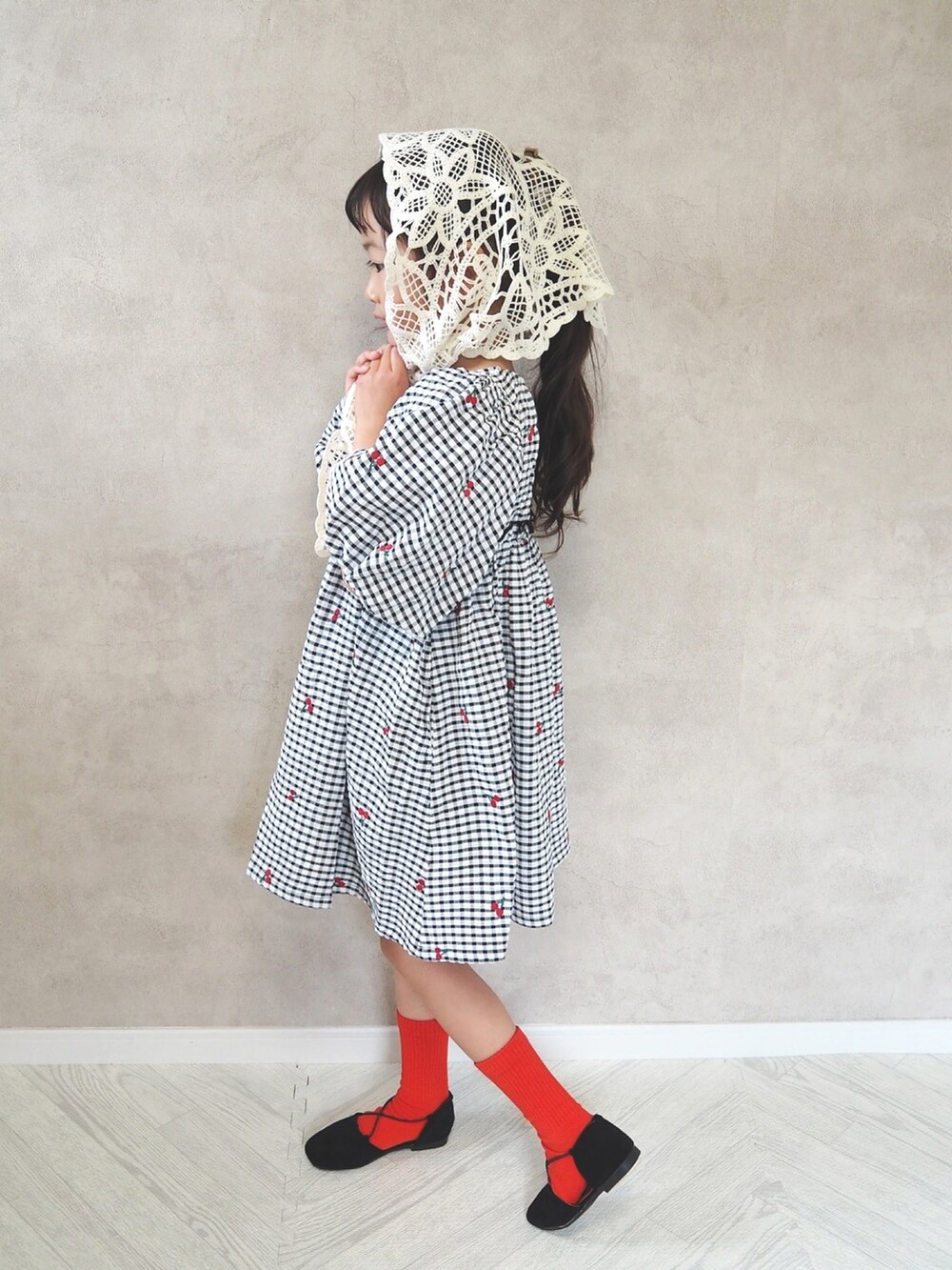 ブラック系のワンピース、レッド系のソックス/靴下、ブルー系のキャップを着用したキッズの春コーディネートの3枚目の写真