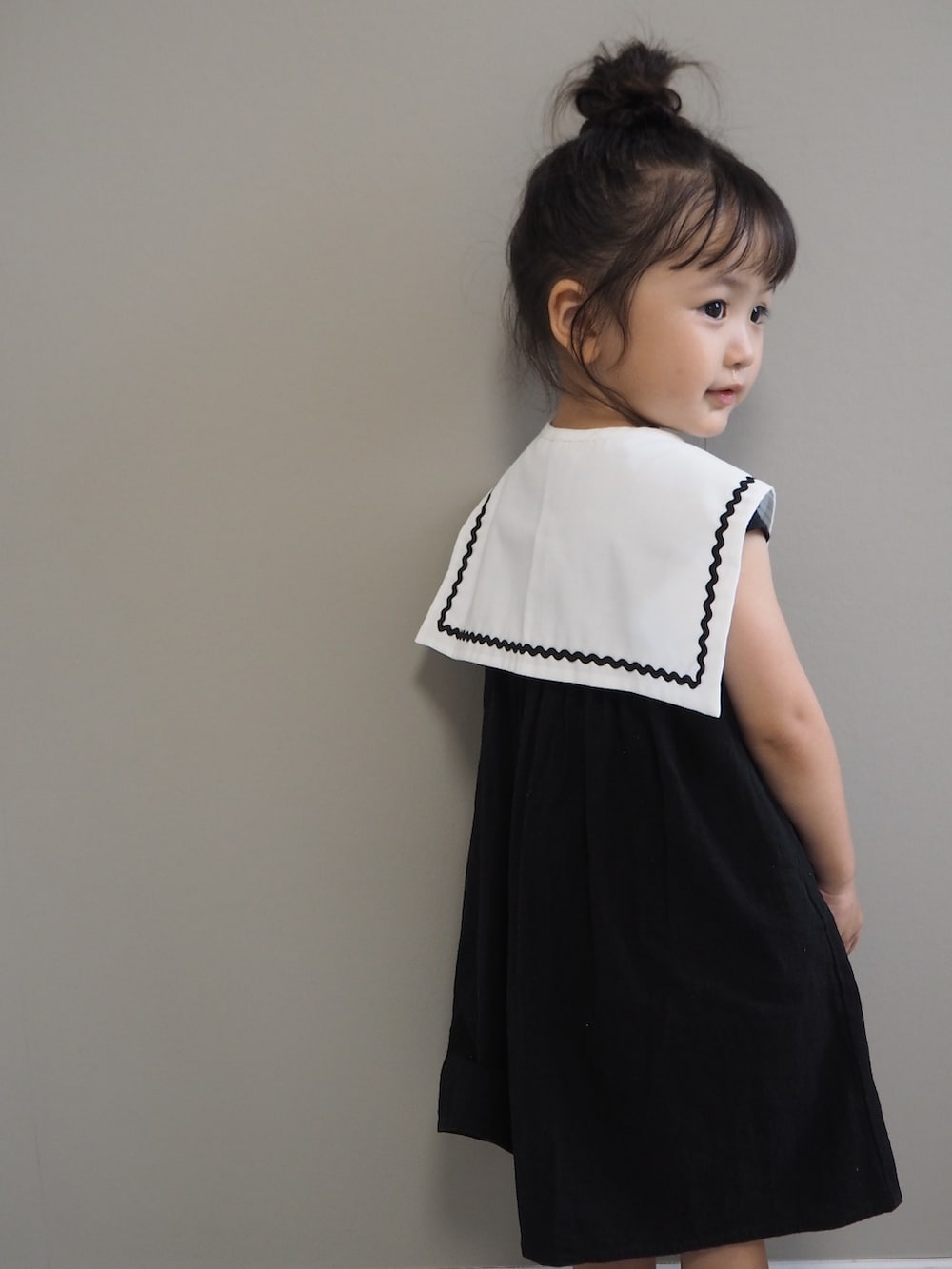 ブラック系のワンピース、ホワイト系の付け襟を着用したキッズの夏コーディネートの2枚目の写真