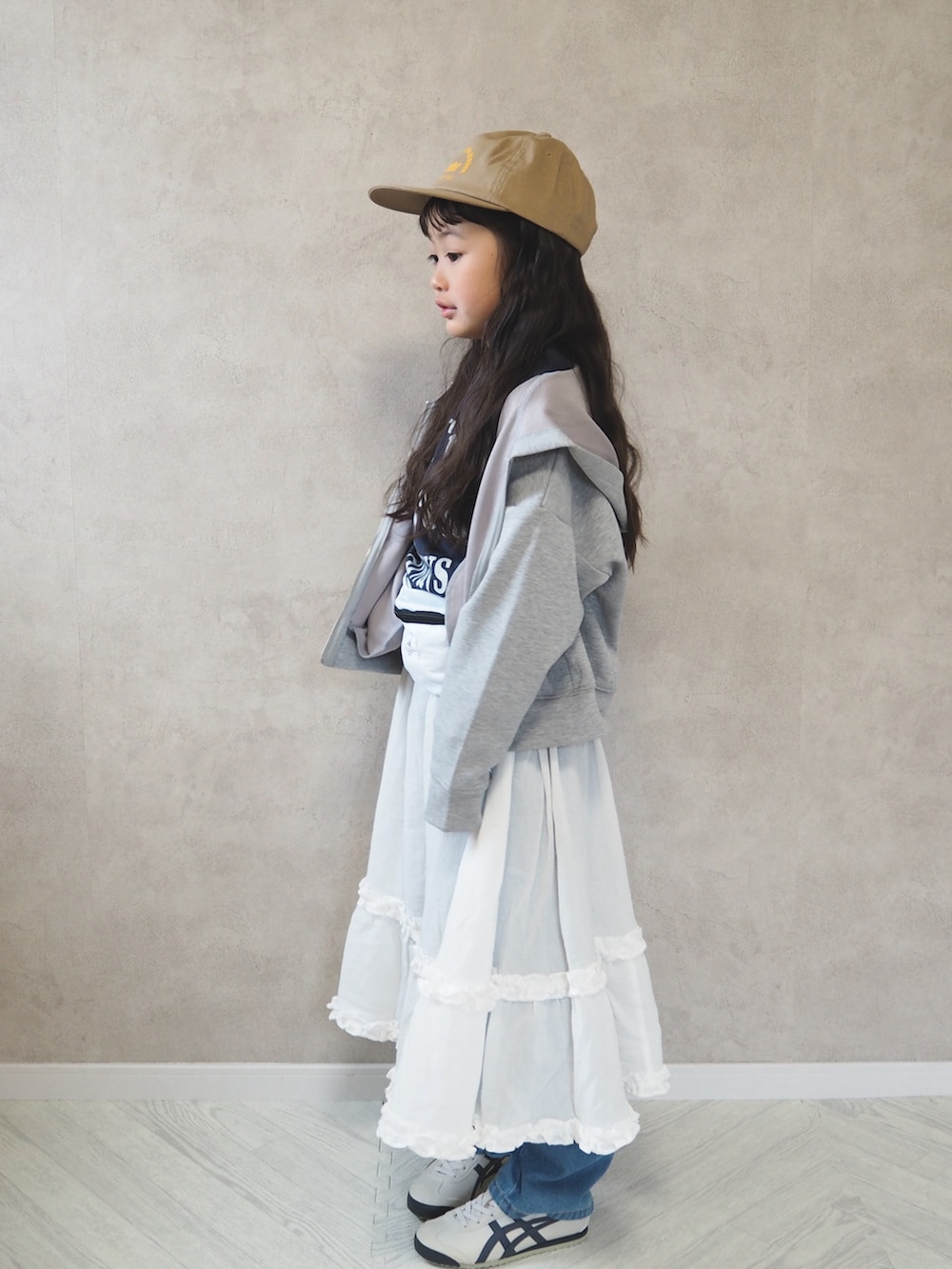ブルー系のTシャツ/カットソー、ホワイト系のスカート、グレー系のパーカーを着用したキッズの春コーディネートの3枚目の写真