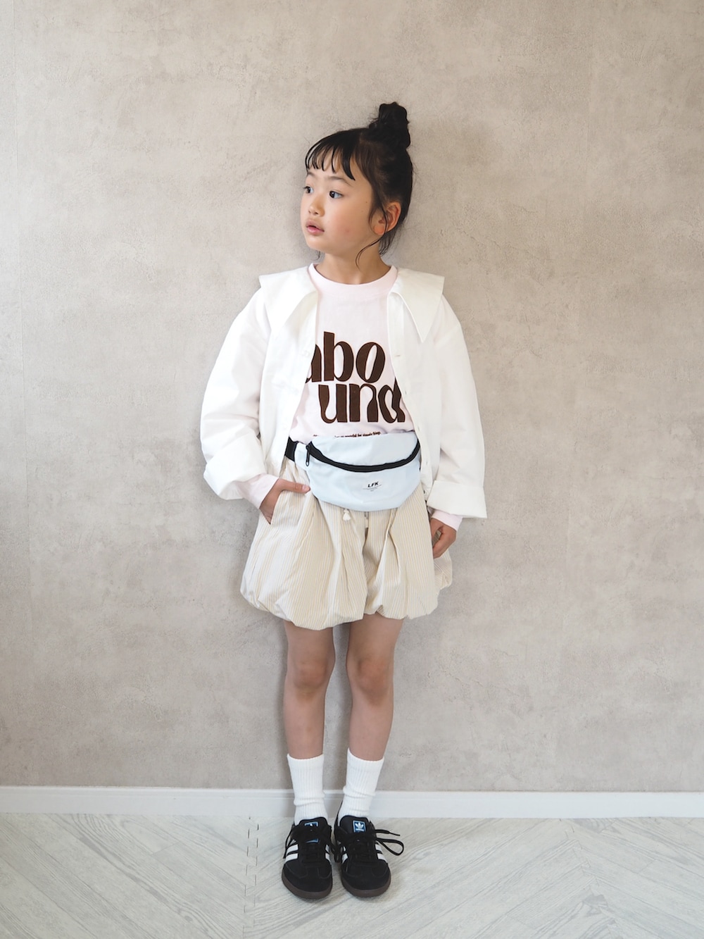 ピンク系のTシャツ/カットソー、ホワイト系のシャツ/ブラウス、ブラック系のスニーカーを着用したキッズの春コーディネートの3枚目の写真