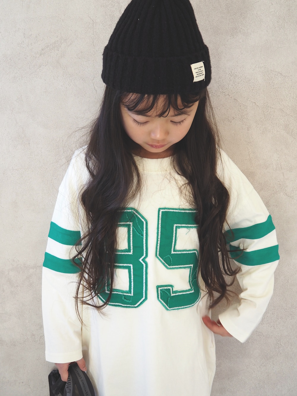 ブラック系のスニーカー、ホワイト系のワンピース、ブラック系のショルダーバッグを着用したキッズの冬コーディネートの5枚目の写真