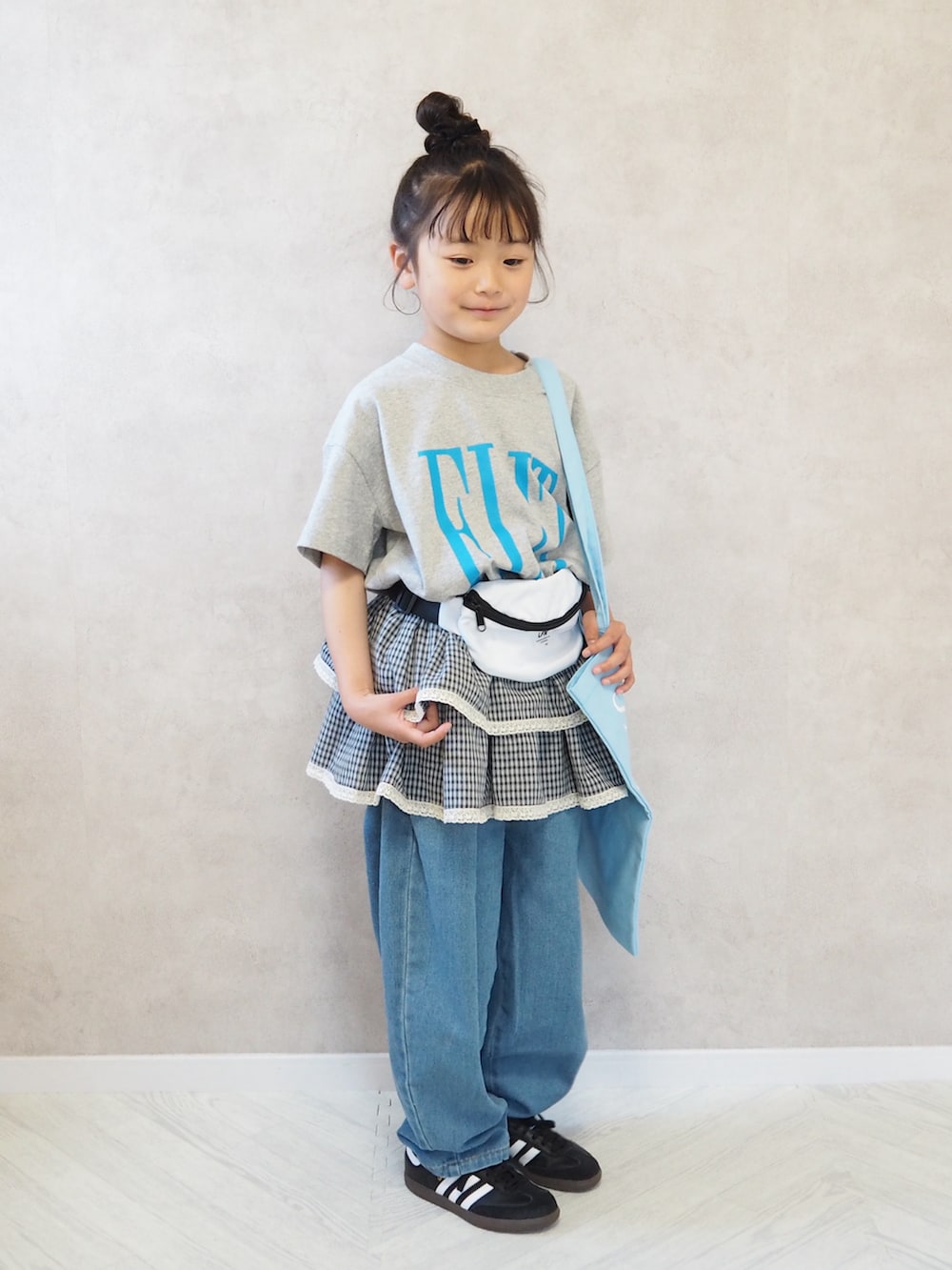 ブラック系のスニーカー、グレー系のTシャツ/カットソー、ブルー系のデニムパンツを着用したキッズの春コーディネートの3枚目の写真
