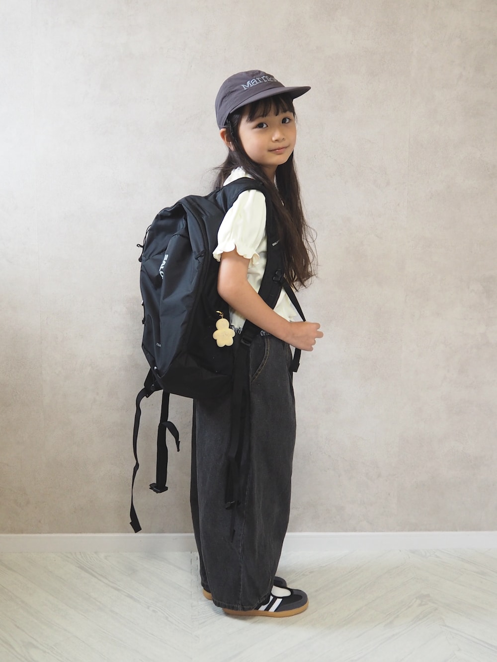 ブラック系のデニムパンツ、ブラック系のスニーカー、ホワイト系のTシャツ/カットソーを着用したキッズの夏コーディネートの3枚目の写真