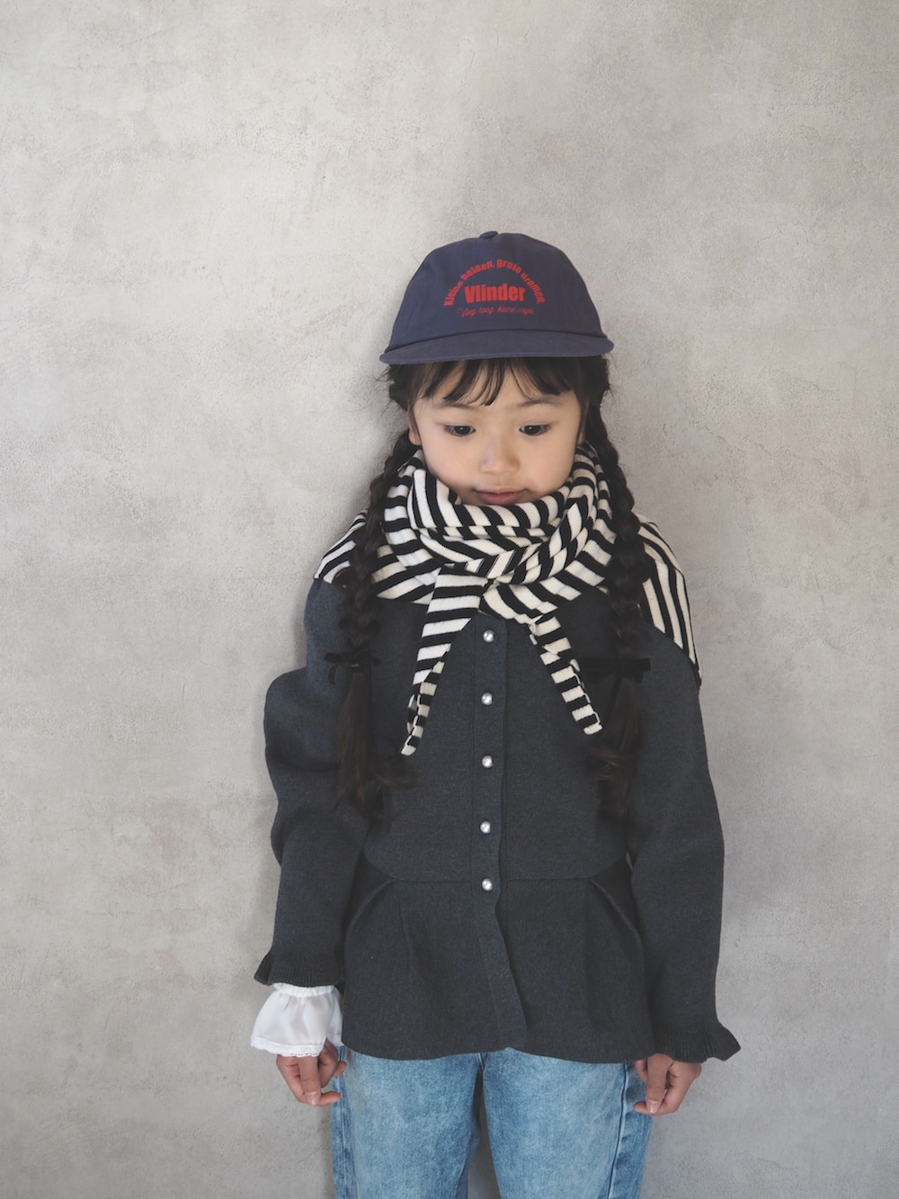 ブラック系のスニーカー、グレー系のカーディガン/ボレロ、ブルー系のキャップを着用したキッズの冬コーディネートの4枚目の写真