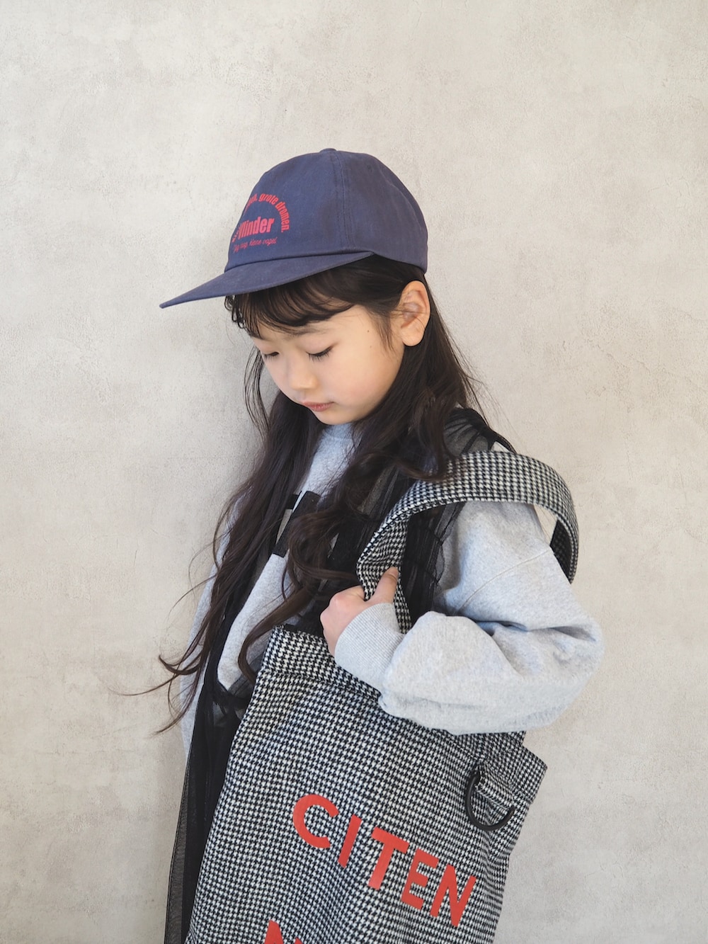 グレー系のスウェット、ブラック系のトートバッグ、ブラック系のチュニックを着用したキッズの冬コーディネートの4枚目の写真