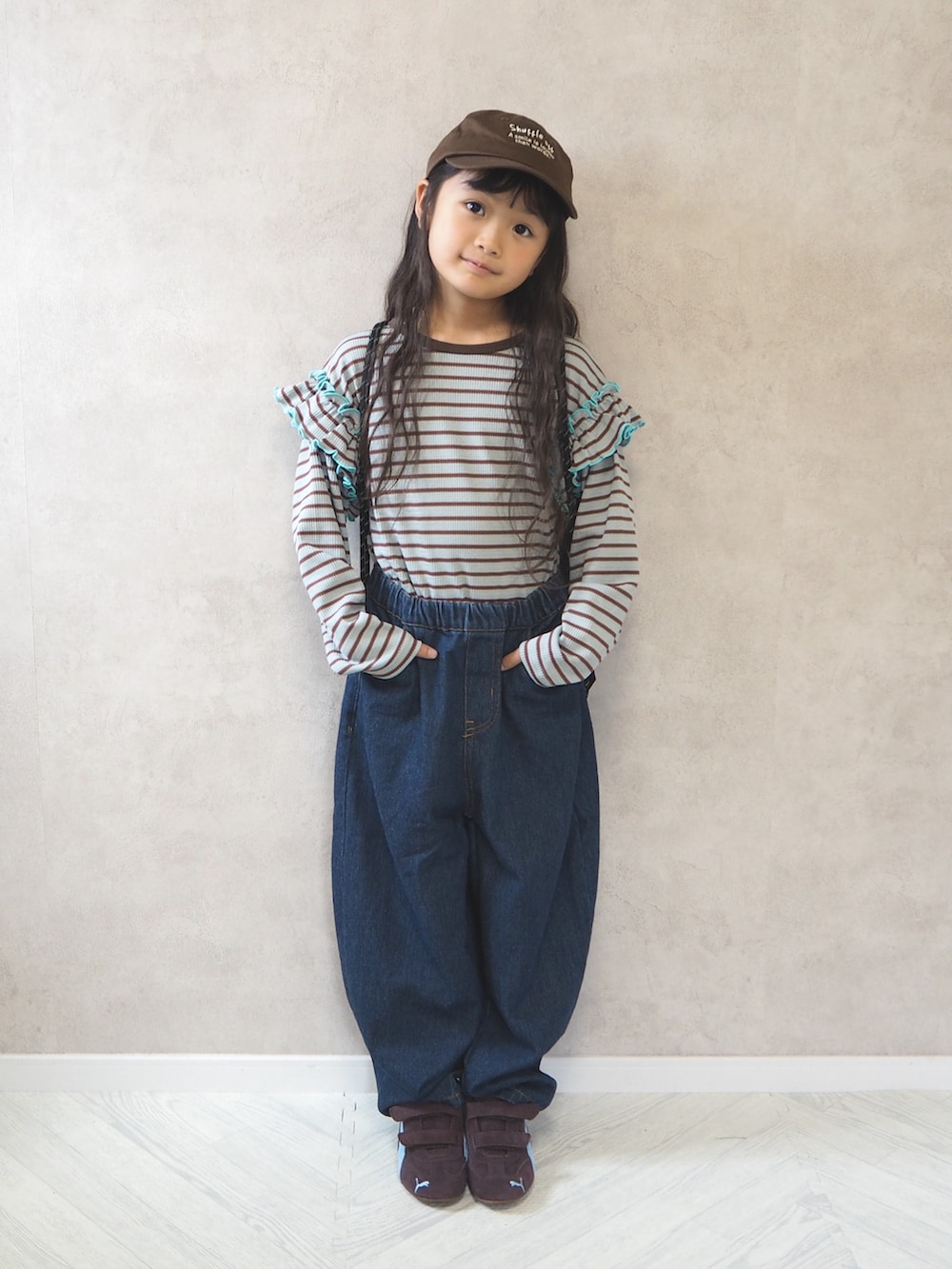 ブラック系のバックパック/リュック、グリーン系のTシャツ/カットソー、ブルー系のデニムパンツを着用したキッズの秋コーディネートの2枚目の写真