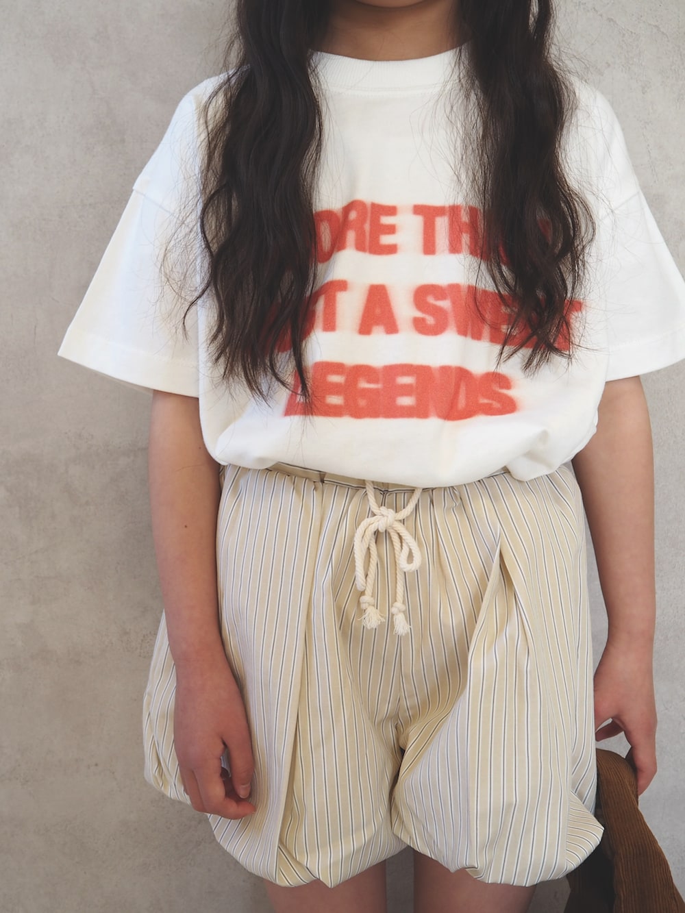 ブラック系のスニーカー、ホワイト系のTシャツ/カットソー、ベージュ系のその他パンツを着用したキッズの春コーディネートの4枚目の写真