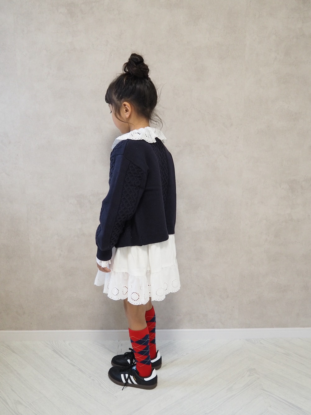 ホワイト系のワンピース、ブルー系のカーディガン/ボレロ、レッド系のソックス/靴下を着用したキッズの秋コーディネートの3枚目の写真
