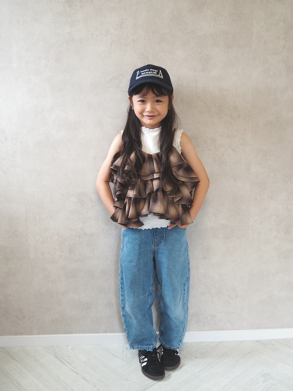 ブラウン系のキャミソール、ブルー系のパンツ、ブルー系のキャップを着用したキッズの夏コーディネートの3枚目の写真