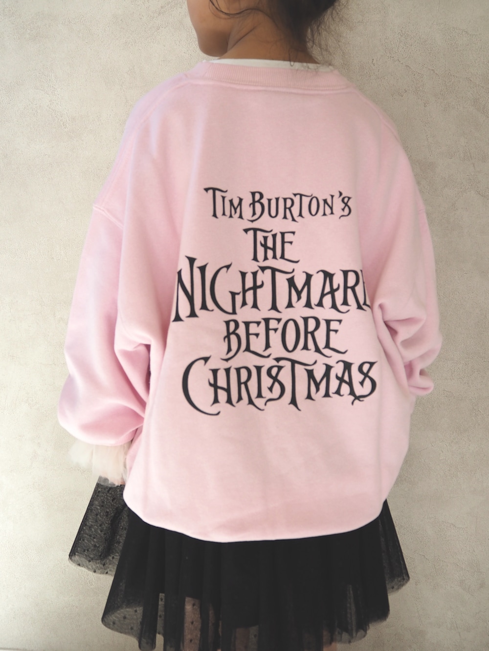 ピンク系のスウェット、ピンク系のショルダーバッグ、ブラック系のスカートを着用したキッズの冬コーディネートの4枚目の写真