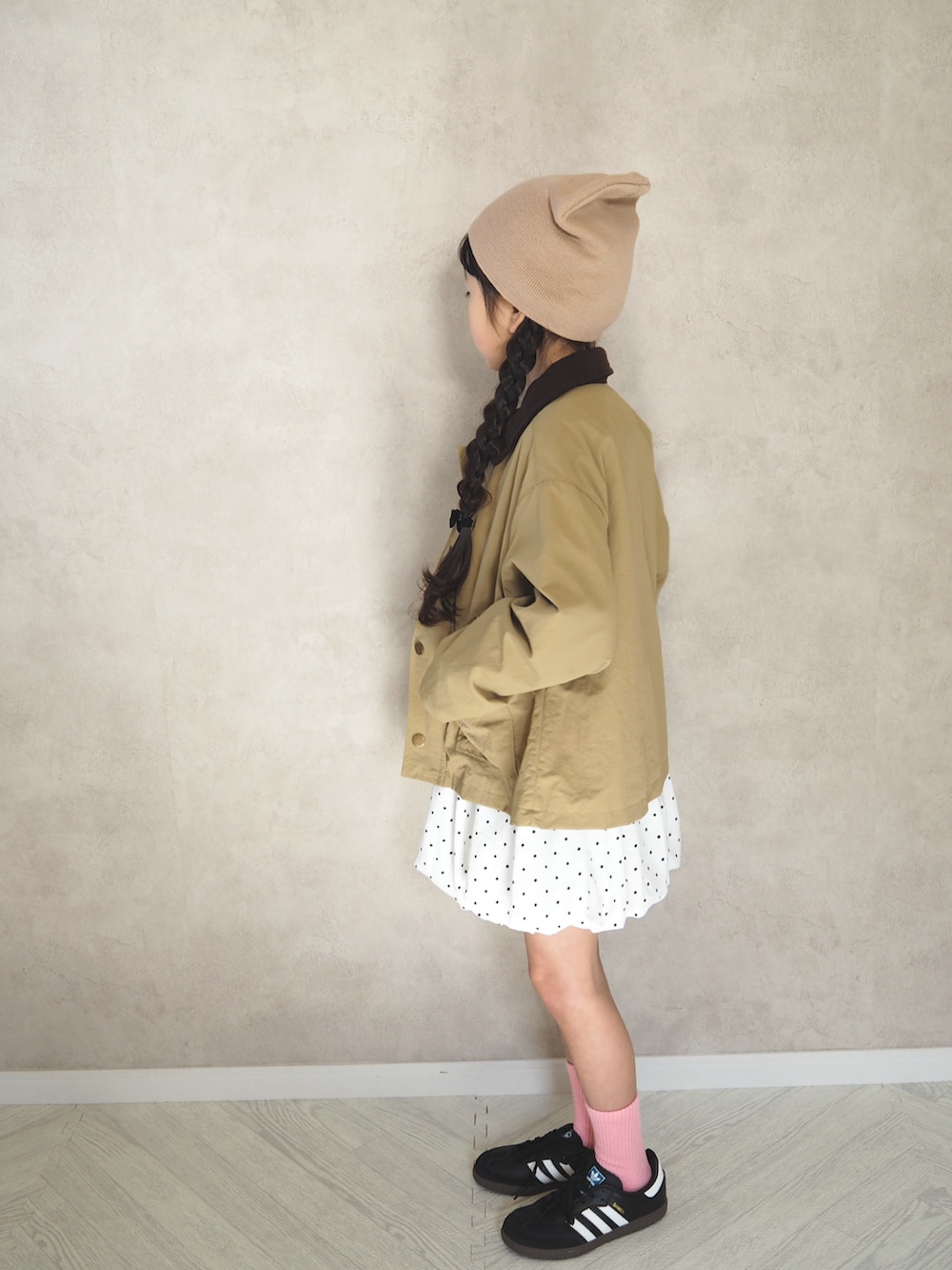ホワイト系のスカート、ブラック系のスニーカー、グレー系のTシャツ/カットソーを着用したキッズの冬コーディネートの2枚目の写真