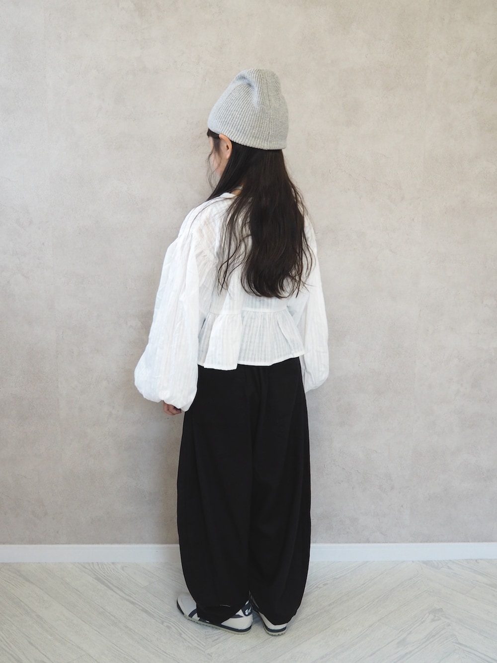 ブラック系のその他パンツ、ホワイト系のカーディガン/ボレロ、グレー系のタンクトップを着用したキッズの春コーディネートの3枚目の写真
