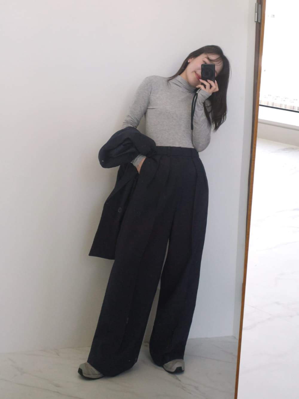 ブルー系のスーツセットを着用したレディースの冬コーディネートの2枚目の写真