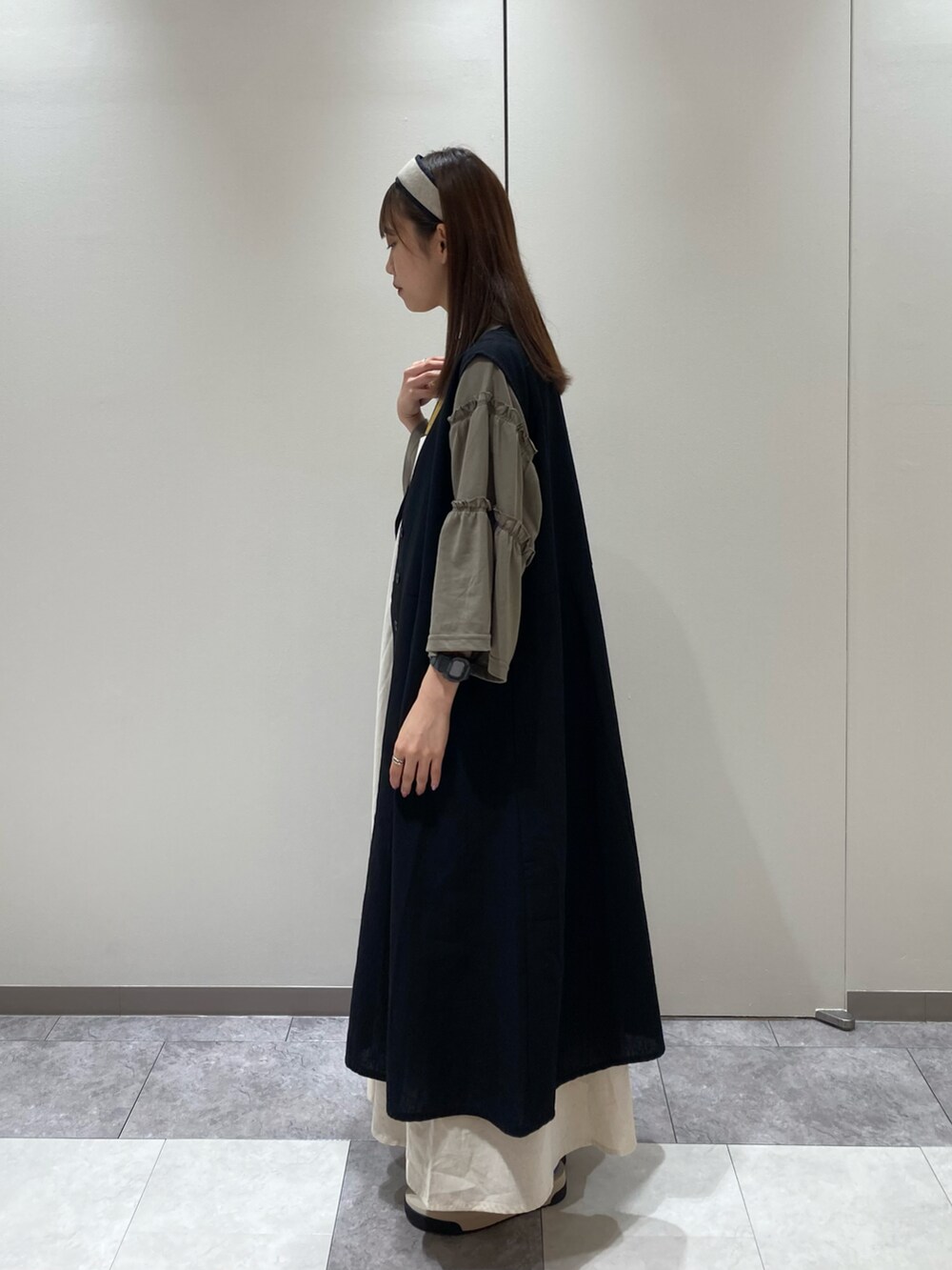 グリーン系のTシャツ/カットソー、ブラック系のワンピース、ブラック系のハンドバッグを着用したレディースの夏コーディネートの2枚目の写真