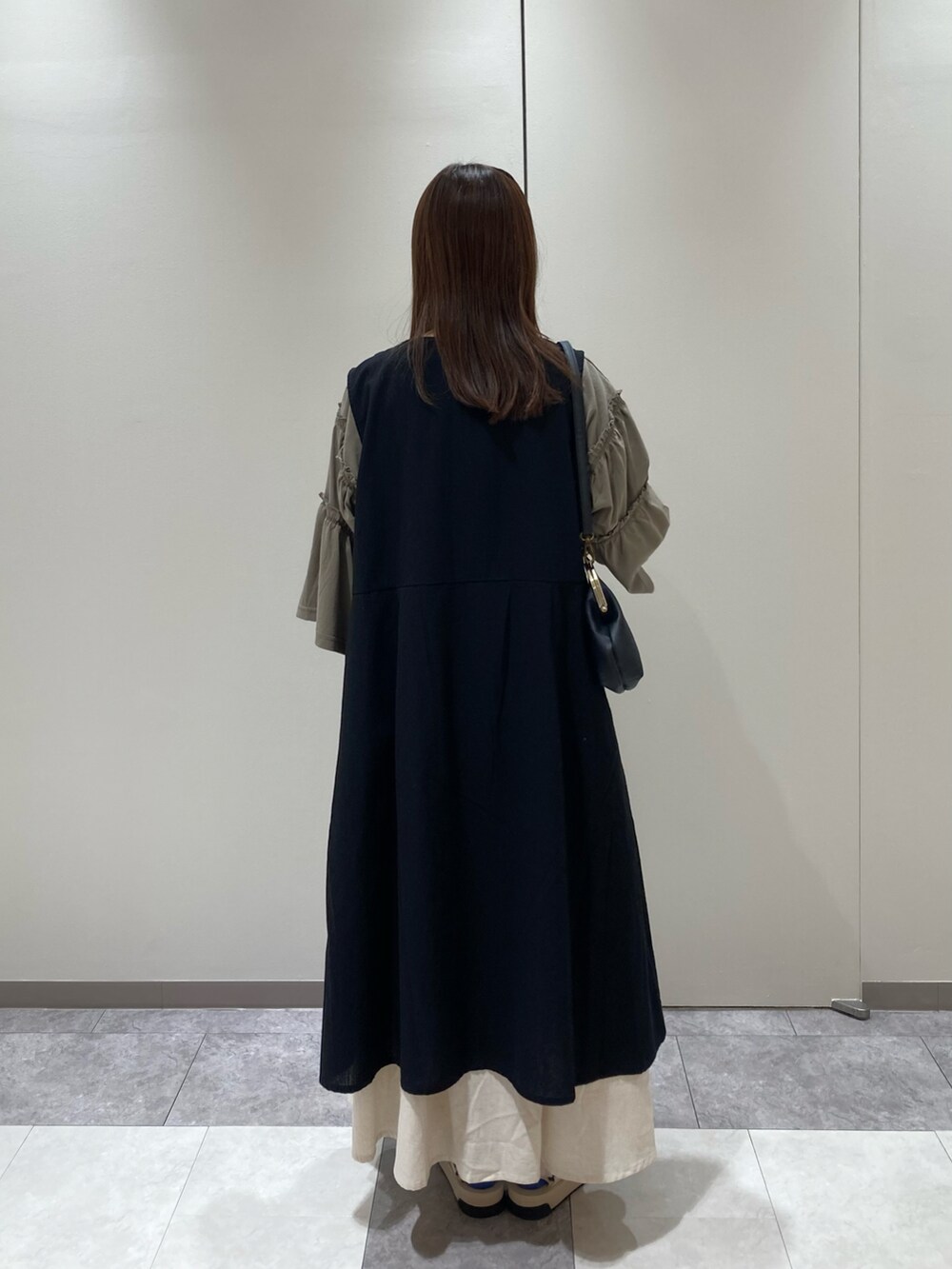 グリーン系のTシャツ/カットソー、ブラック系のワンピース、ブラック系のハンドバッグを着用したレディースの夏コーディネートの3枚目の写真