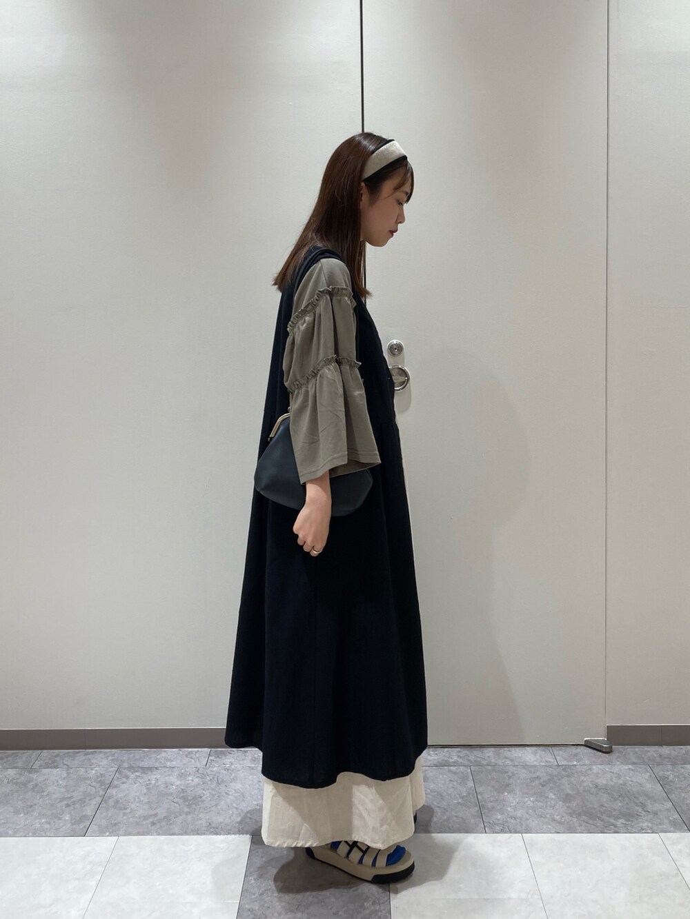 グリーン系のTシャツ/カットソー、ブラック系のワンピース、ブラック系のハンドバッグを着用したレディースの夏コーディネートの4枚目の写真