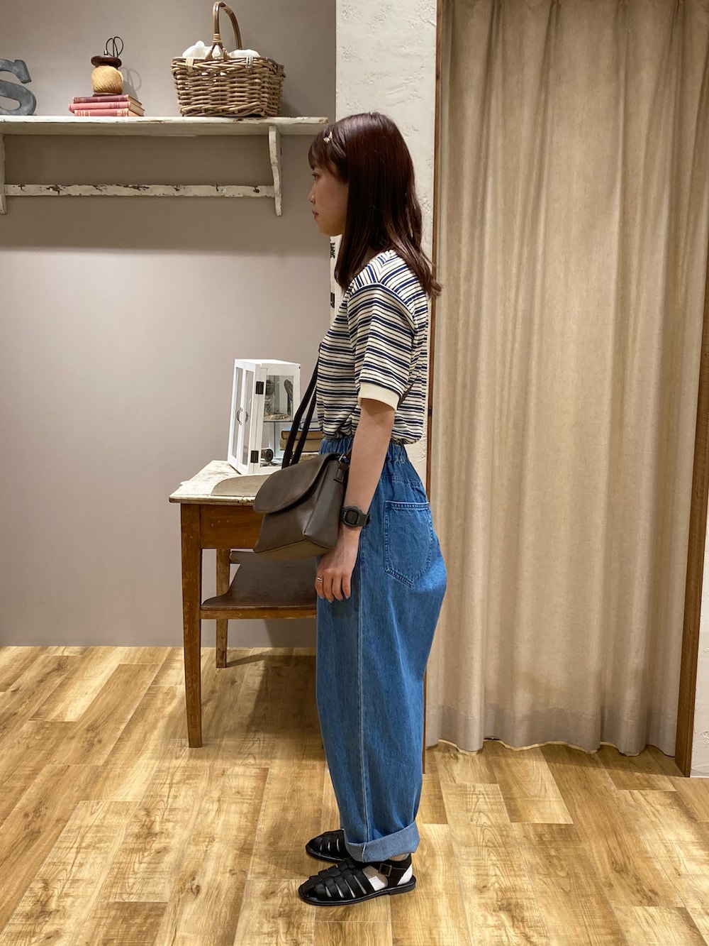 ブルー系のTシャツ/カットソー、ブルー系のデニムパンツ、ブラウン系のハンドバッグを着用したレディースの夏コーディネートの2枚目の写真