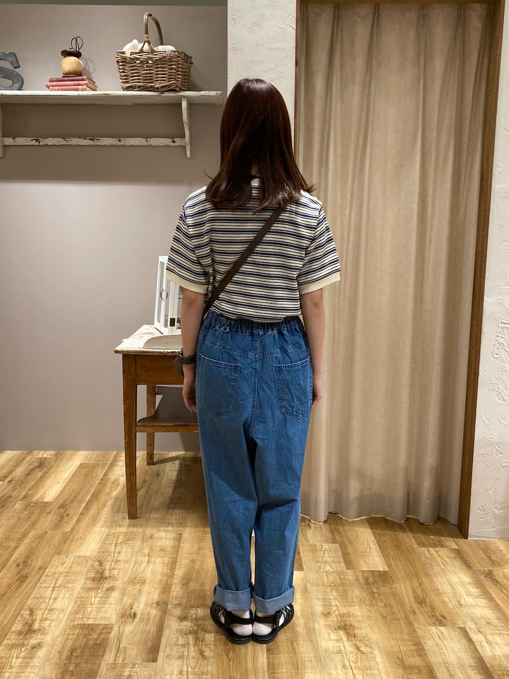 ブルー系のTシャツ/カットソー、ブルー系のデニムパンツ、ブラウン系のハンドバッグを着用したレディースの夏コーディネートの3枚目の写真