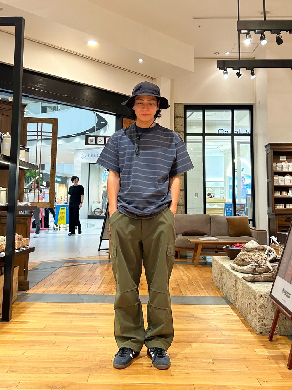 ブルー系のTシャツ/カットソー、グリーン系のカーゴパンツ、ブラック系のスニーカーを着用したメンズの夏コーディネートの2枚目の写真