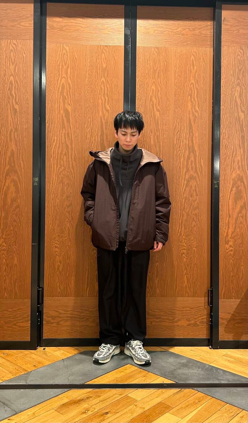 ブルー系のその他パンツ、ブラウン系のダウンジャケット/コート、グレー系のTシャツ/カットソーを着用したメンズの冬コーディネートの2枚目の写真