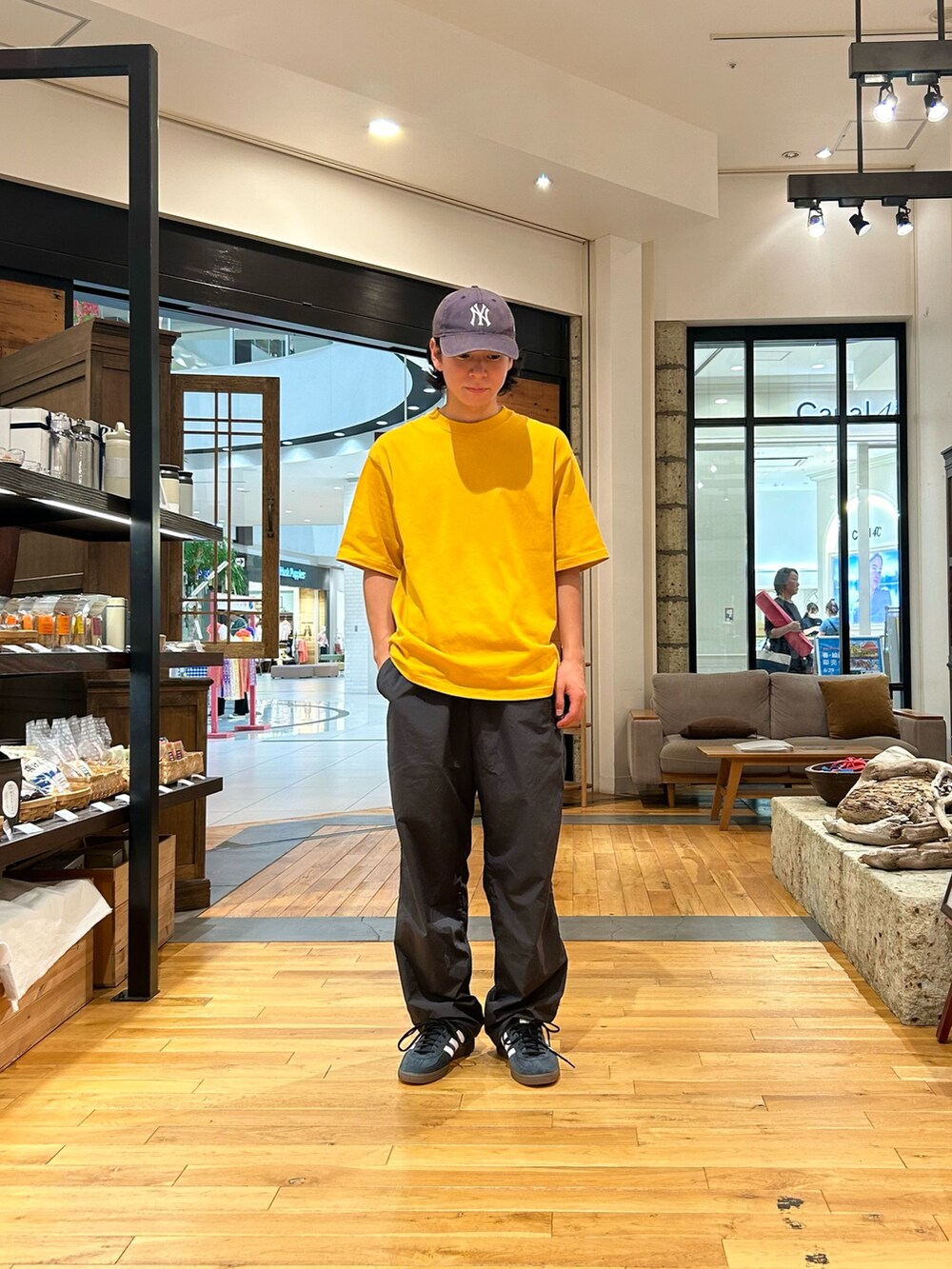 イエロー系のTシャツ/カットソー、グレー系のその他パンツ、ブラック系のスニーカーを着用したメンズの夏コーディネートの3枚目の写真