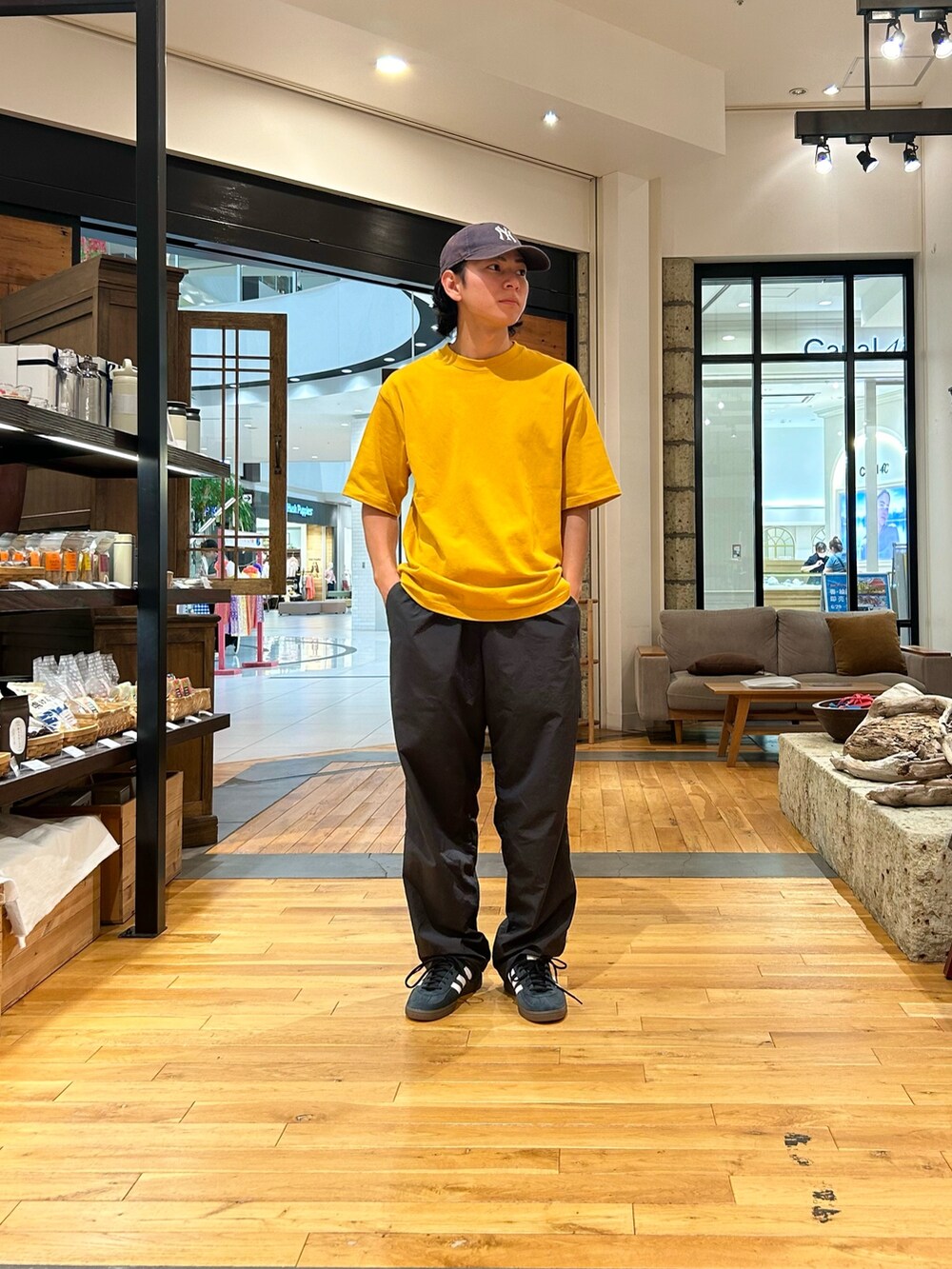 イエロー系のTシャツ/カットソー、グレー系のその他パンツ、ブラック系のスニーカーを着用したメンズの夏コーディネートの2枚目の写真