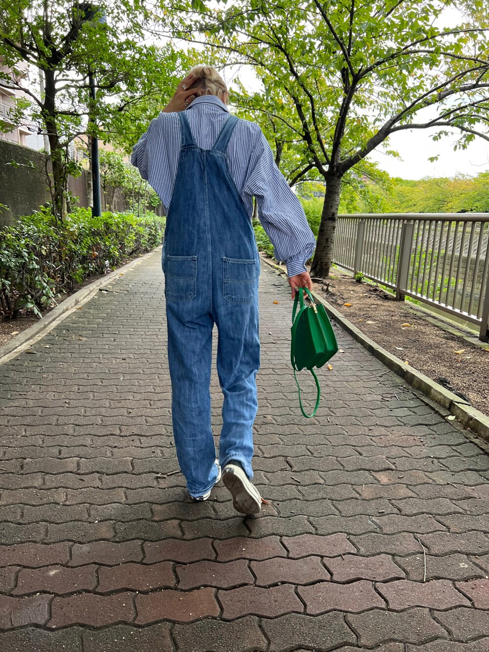 ブルー系のサロペット/オーバーオール、ブラック系のスニーカー、ブルー系のシャツ/ブラウスを着用したレディースの秋コーディネートの3枚目の写真