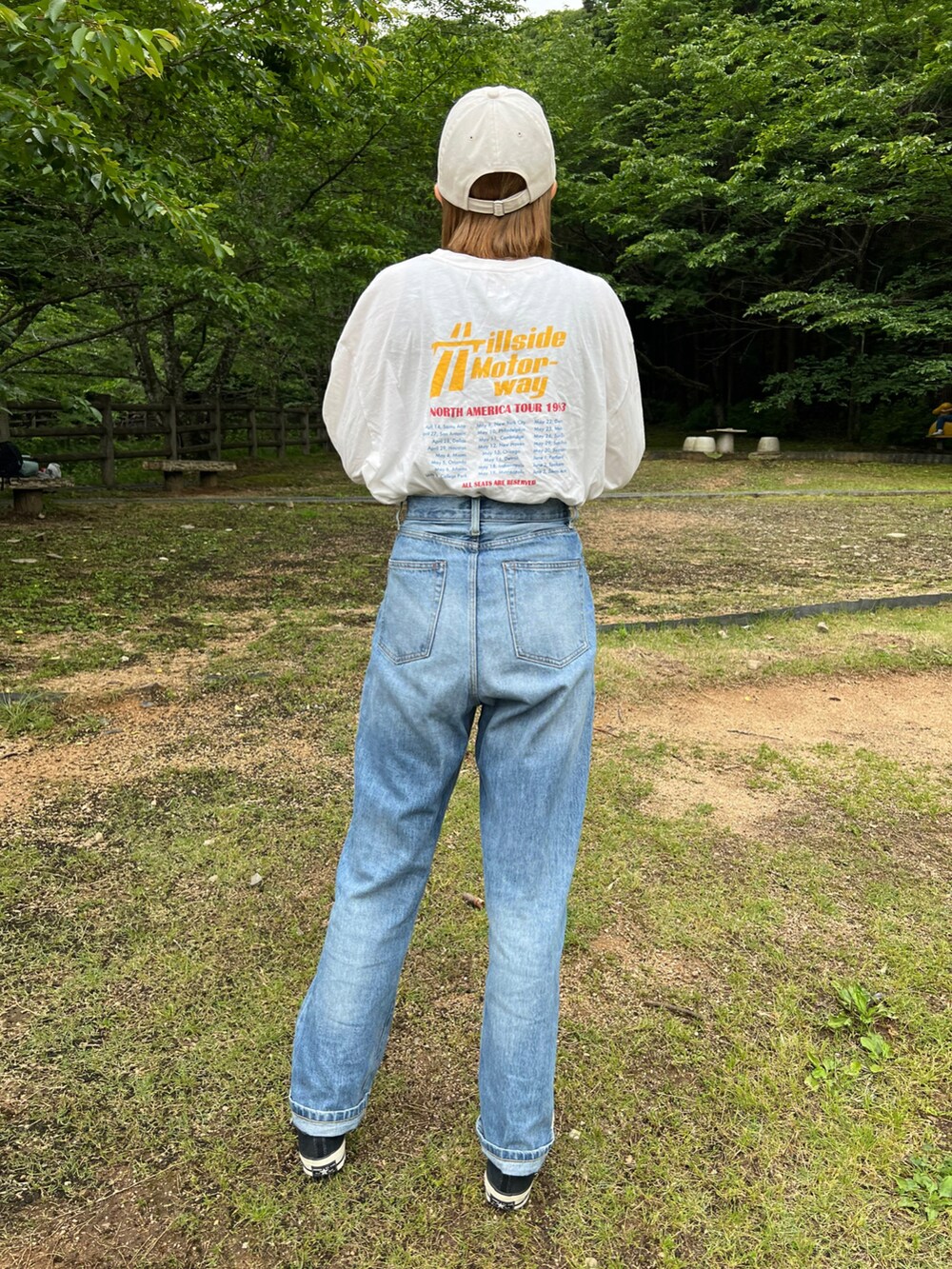 ブルー系のデニムパンツ、ホワイト系のTシャツ/カットソー、オレンジ系のTシャツ/カットソーを着用したレディースの春コーディネートの2枚目の写真