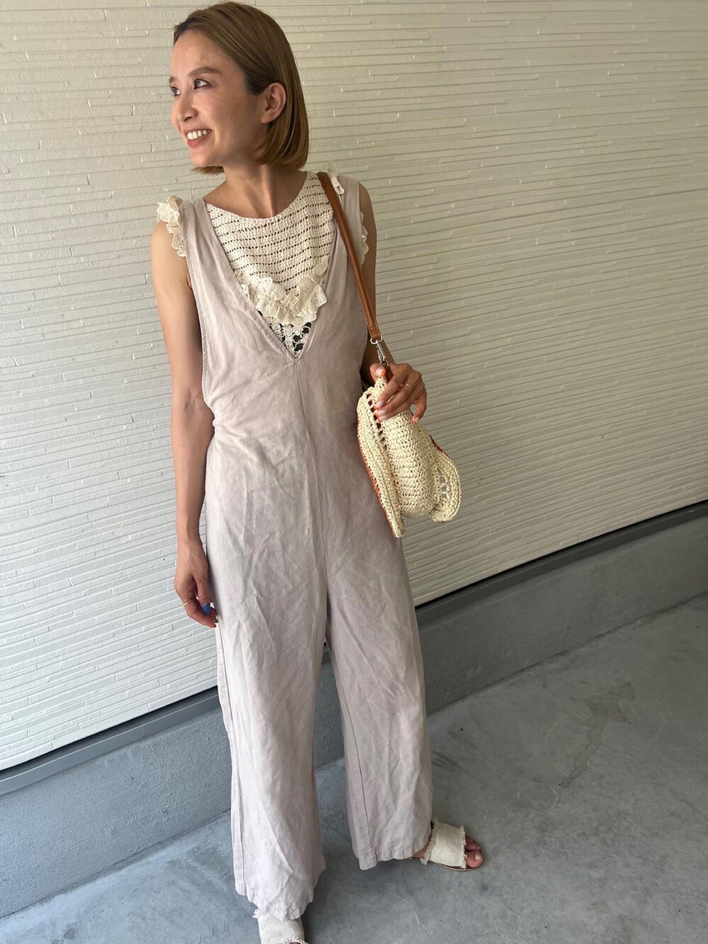 ホワイト系のキャミソール、ベージュ系のサロペット/オーバーオール、ホワイト系のサンダルを着用したレディースの夏コーディネートの2枚目の写真