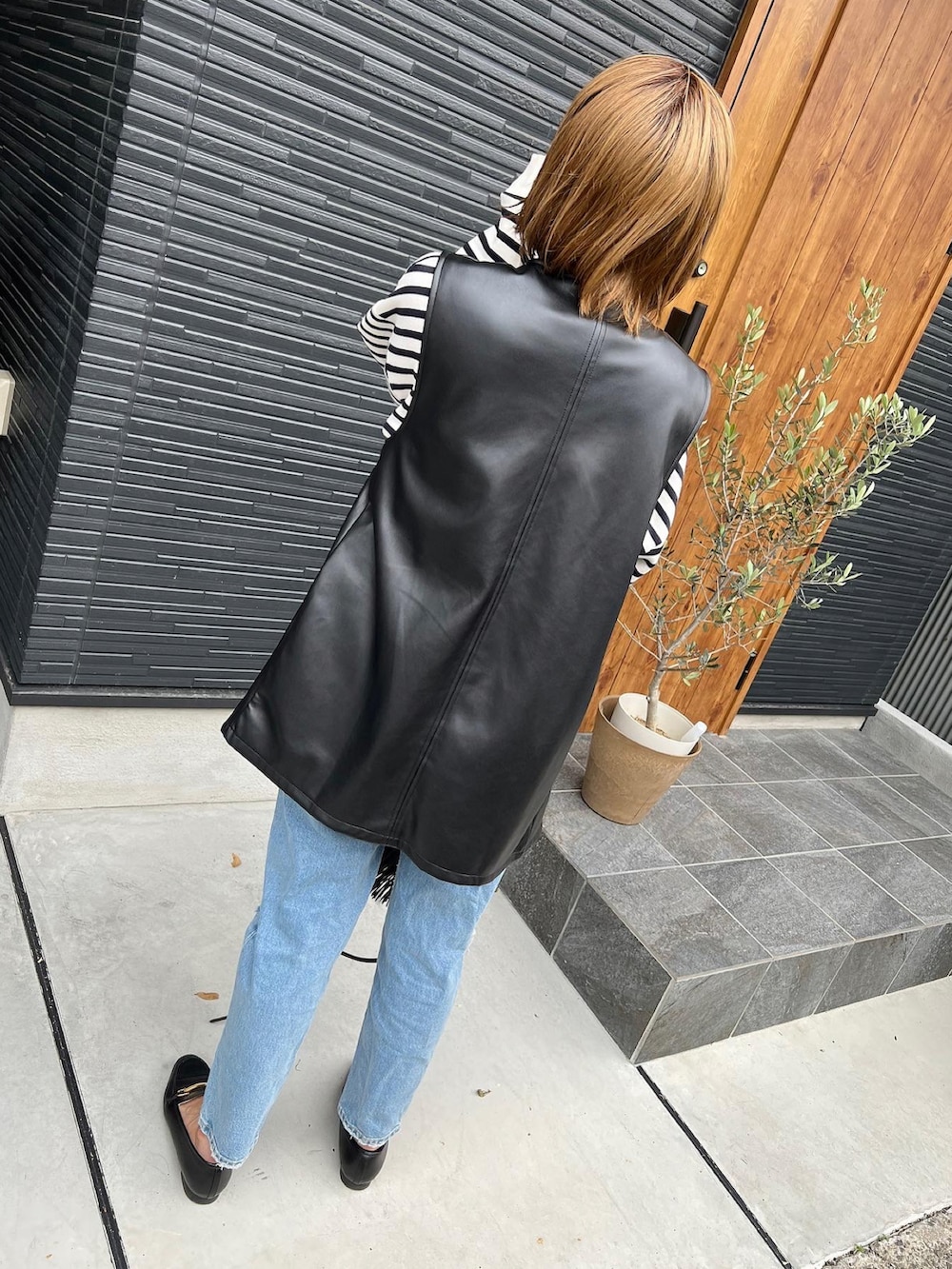 ブラック系のショルダーバッグ、ブラック系のローファー、ホワイト系のTシャツ/カットソーを着用したレディースの夏コーディネートの2枚目の写真