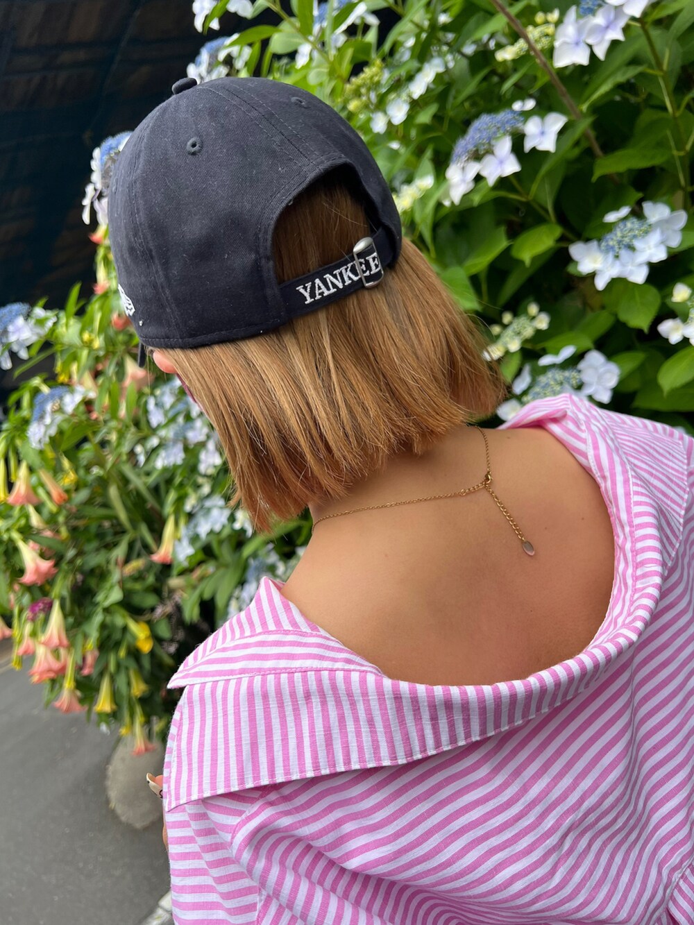 ピンク系のシャツ/ブラウス、ブラック系のサンダル、ブルー系のキャップを着用したレディースの夏コーディネートの2枚目の写真