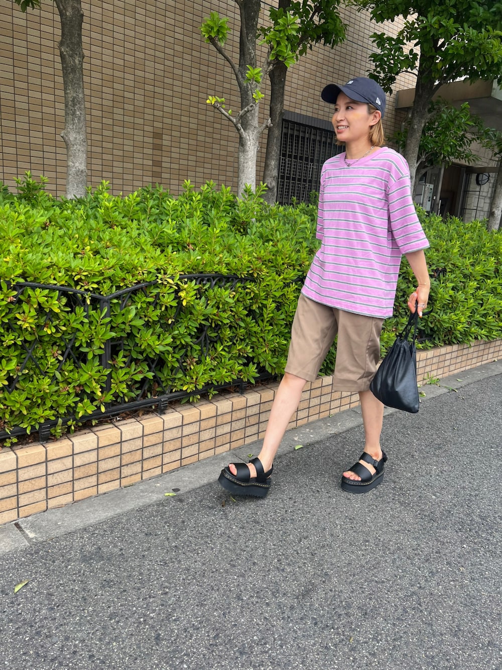 ピンク系のTシャツ/カットソー、ブラック系のサンダル、ブラウン系のその他パンツを着用したレディースの夏コーディネートの2枚目の写真