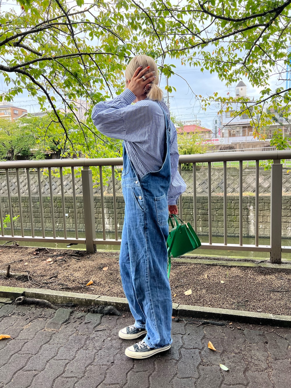 ブルー系のサロペット/オーバーオール、ブラック系のスニーカー、ブルー系のシャツ/ブラウスを着用したレディースの秋コーディネートの2枚目の写真