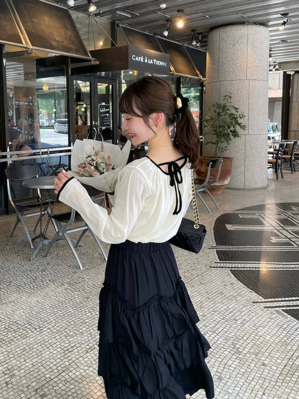 ブラック系のスカート、ホワイト系のTシャツ/カットソー、ホワイト系のTシャツ/カットソーを着用したレディースの秋コーディネートの2枚目の写真