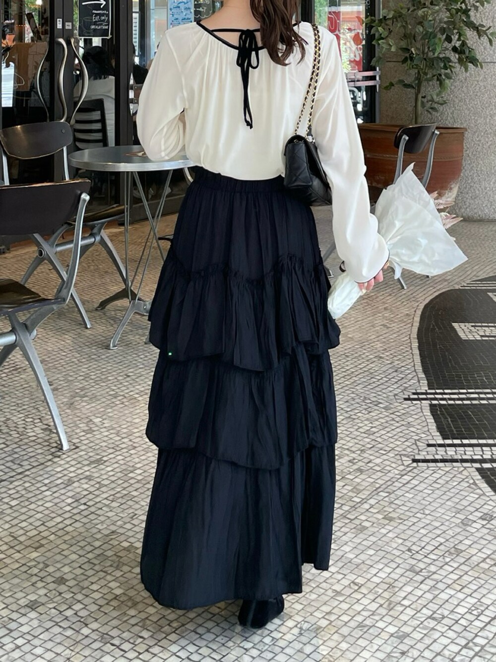 ブラック系のスカート、ホワイト系のTシャツ/カットソー、ホワイト系のTシャツ/カットソーを着用したレディースの秋コーディネートの5枚目の写真