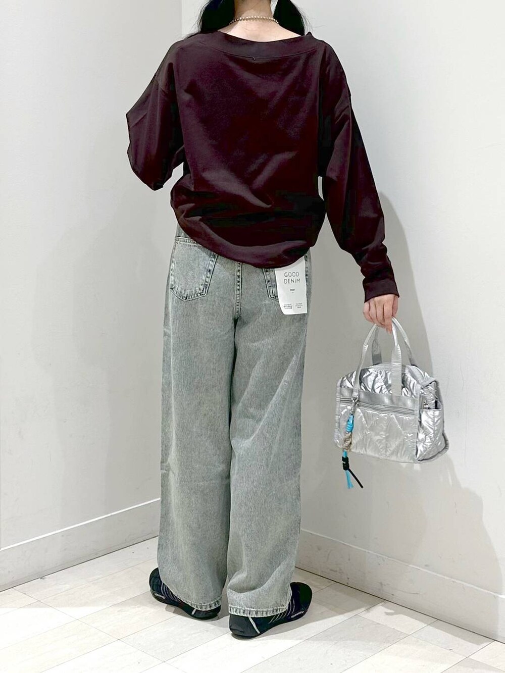 ブルー系のデニムパンツ、シルバー系のボストンバッグを着用したレディースの秋コーディネートの3枚目の写真