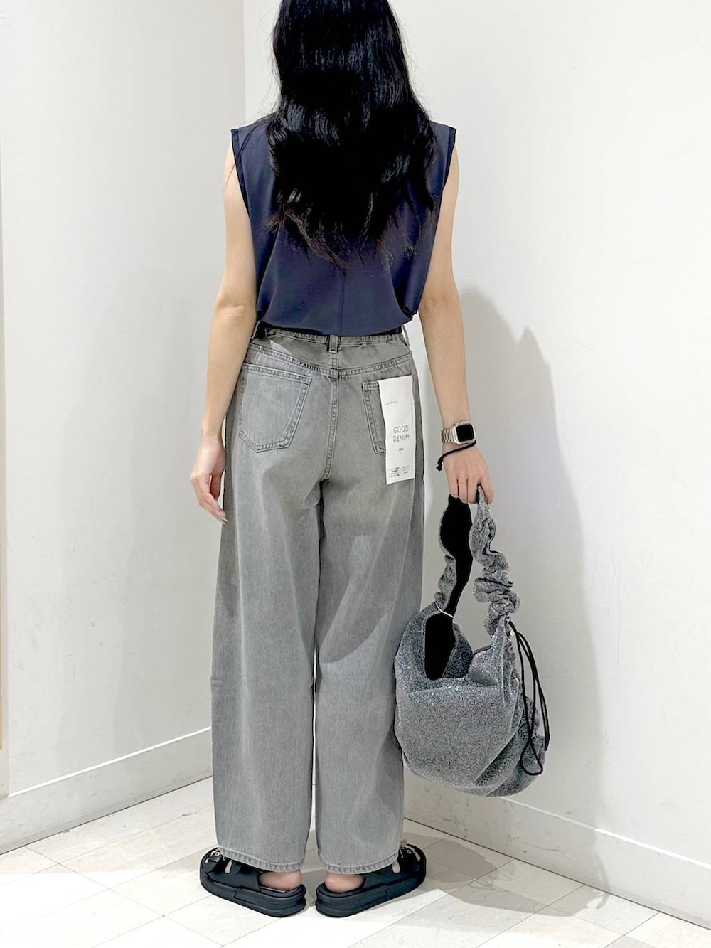 グレー系のデニムパンツ、ブラック系のサンダルを着用したレディースの夏コーディネートの3枚目の写真