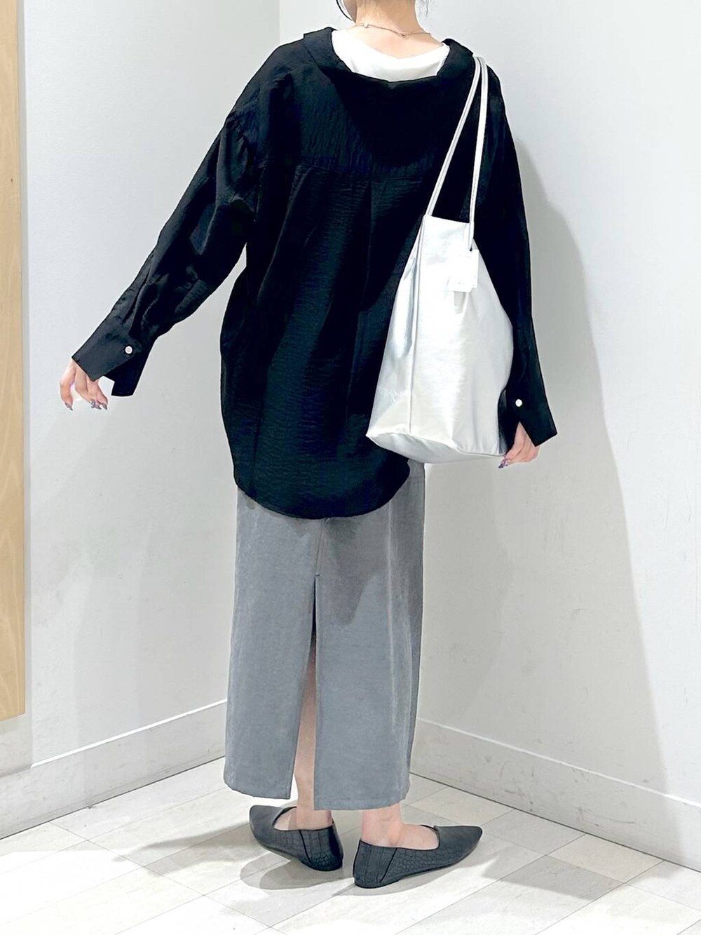 ブラック系のパンプス、ブラック系のシャツ/ブラウス、グレー系のスカートを着用したレディースの秋コーディネートの3枚目の写真