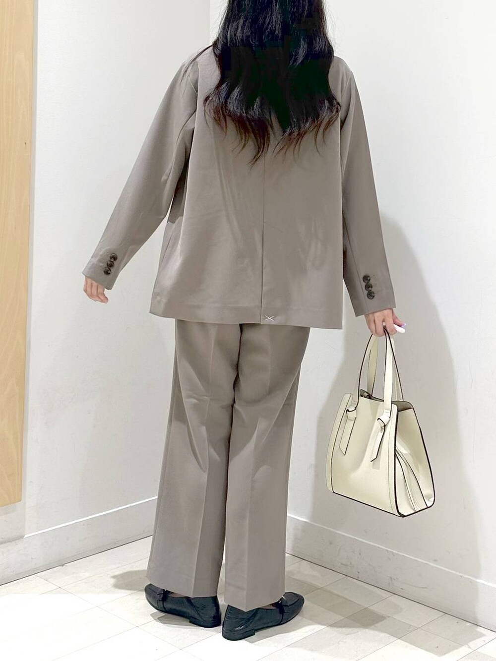 ブラック系のローファー、ホワイト系のショルダーバッグ、ブラウン系のスラックスを着用したレディースの秋コーディネートの3枚目の写真