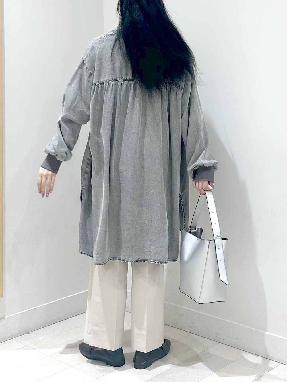 ブラック系のローファー、シルバー系のショルダーバッグ、ベージュ系のスラックスを着用したレディースの秋コーディネートの3枚目の写真