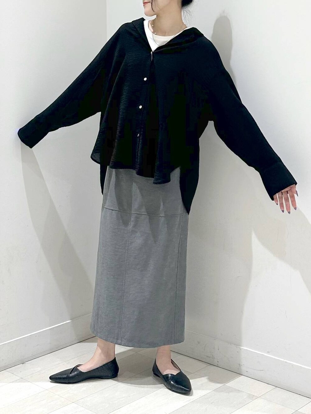 ブラック系のパンプス、ブラック系のシャツ/ブラウス、グレー系のスカートを着用したレディースの秋コーディネートの5枚目の写真