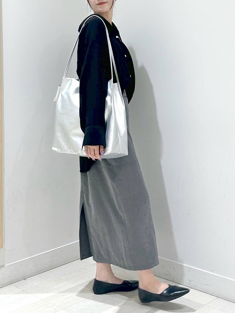 ブラック系のパンプス、ブラック系のシャツ/ブラウス、グレー系のスカートを着用したレディースの秋コーディネートの2枚目の写真