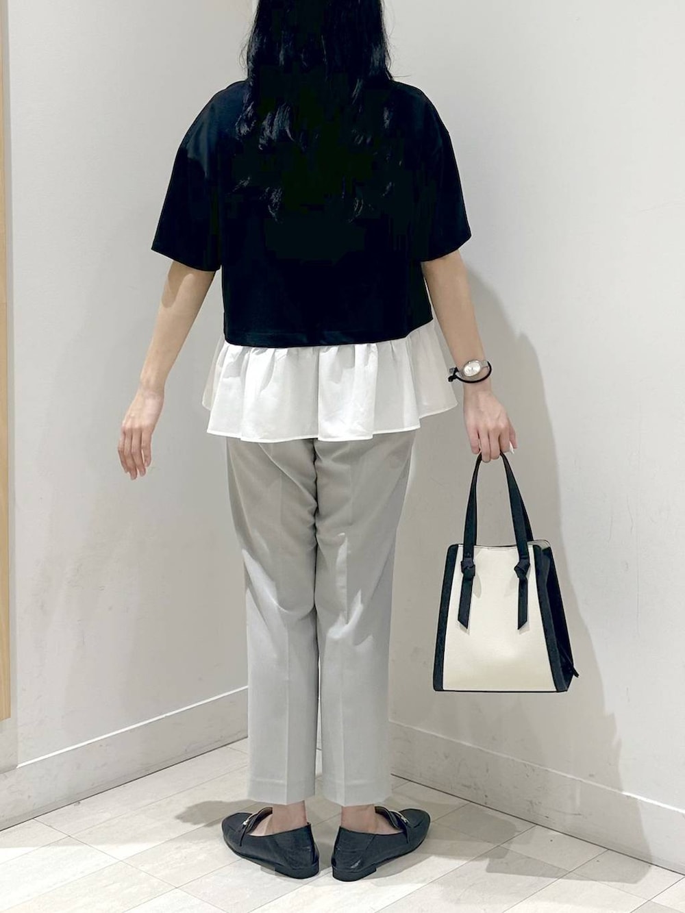 ブラック系のローファー、ホワイト系のショルダーバッグ、ブラック系のTシャツ/カットソーを着用したレディースの夏コーディネートの3枚目の写真