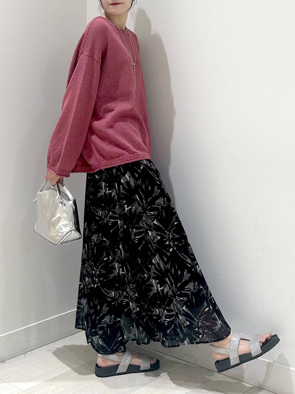 シルバー系のショルダーバッグ、グレー系のサンダル、ブラック系のスカートを着用したレディースの夏コーディネートの2枚目の写真