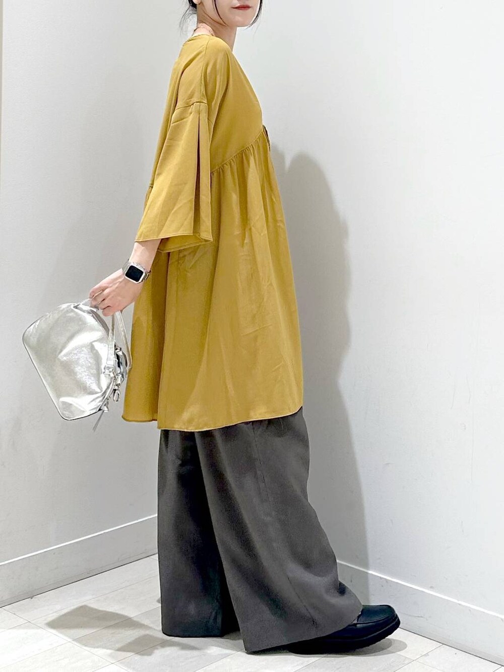 シルバー系のショルダーバッグ、ブラック系のローファー、ホワイト系のキャミソールを着用したレディースの秋コーディネートの2枚目の写真