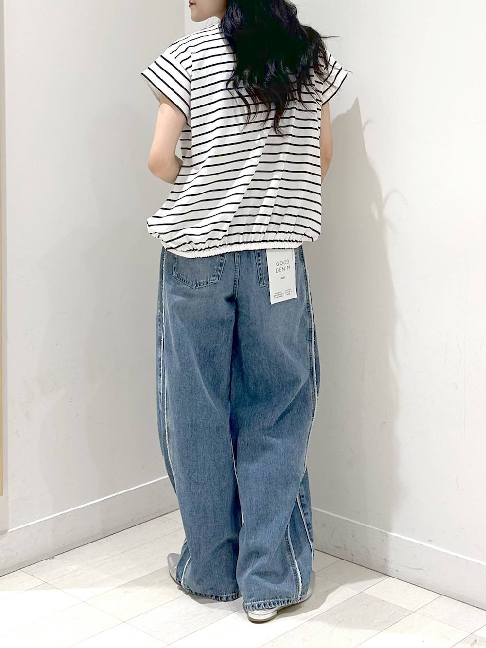 ブルー系のデニムパンツ、シルバー系のサンダル、ホワイト系のTシャツ/カットソーを着用したレディースの夏コーディネートの3枚目の写真
