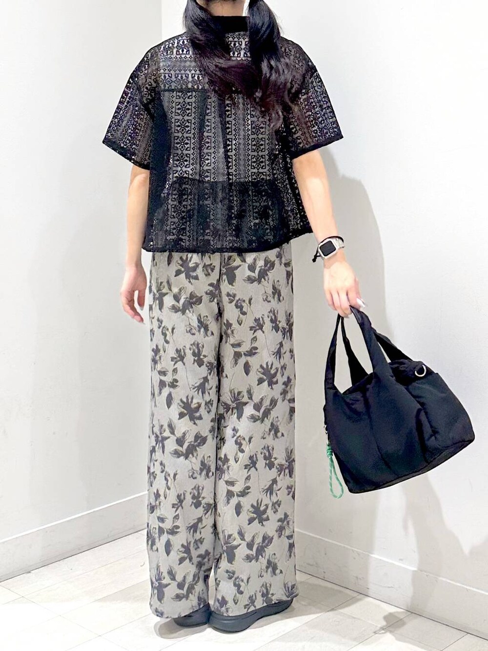 ホワイト系のタンクトップ、ブラック系のトートバッグ、ブラック系のサンダルを着用したレディースの夏コーディネートの3枚目の写真