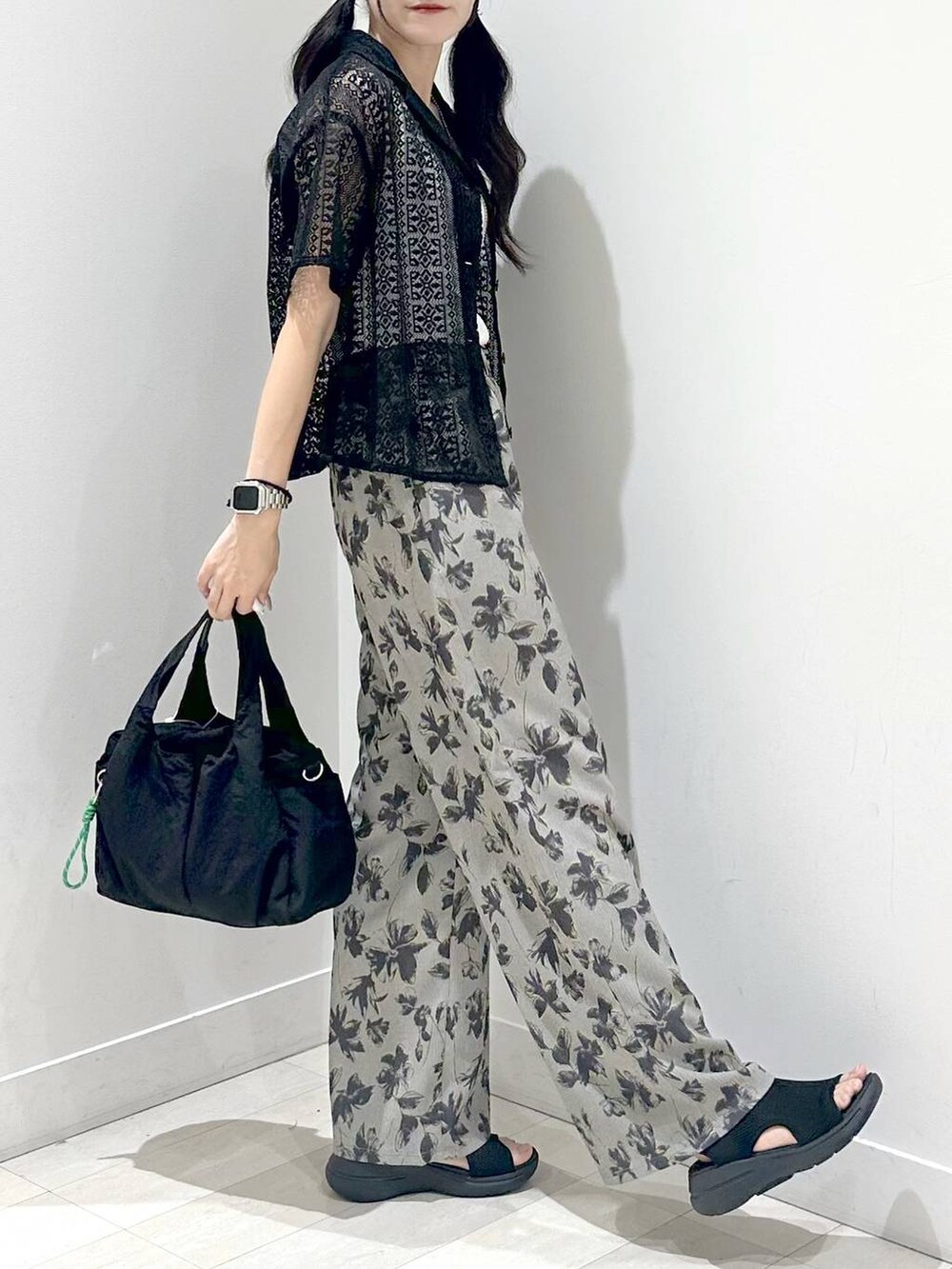 ホワイト系のタンクトップ、ブラック系のトートバッグ、ブラック系のサンダルを着用したレディースの夏コーディネートの2枚目の写真