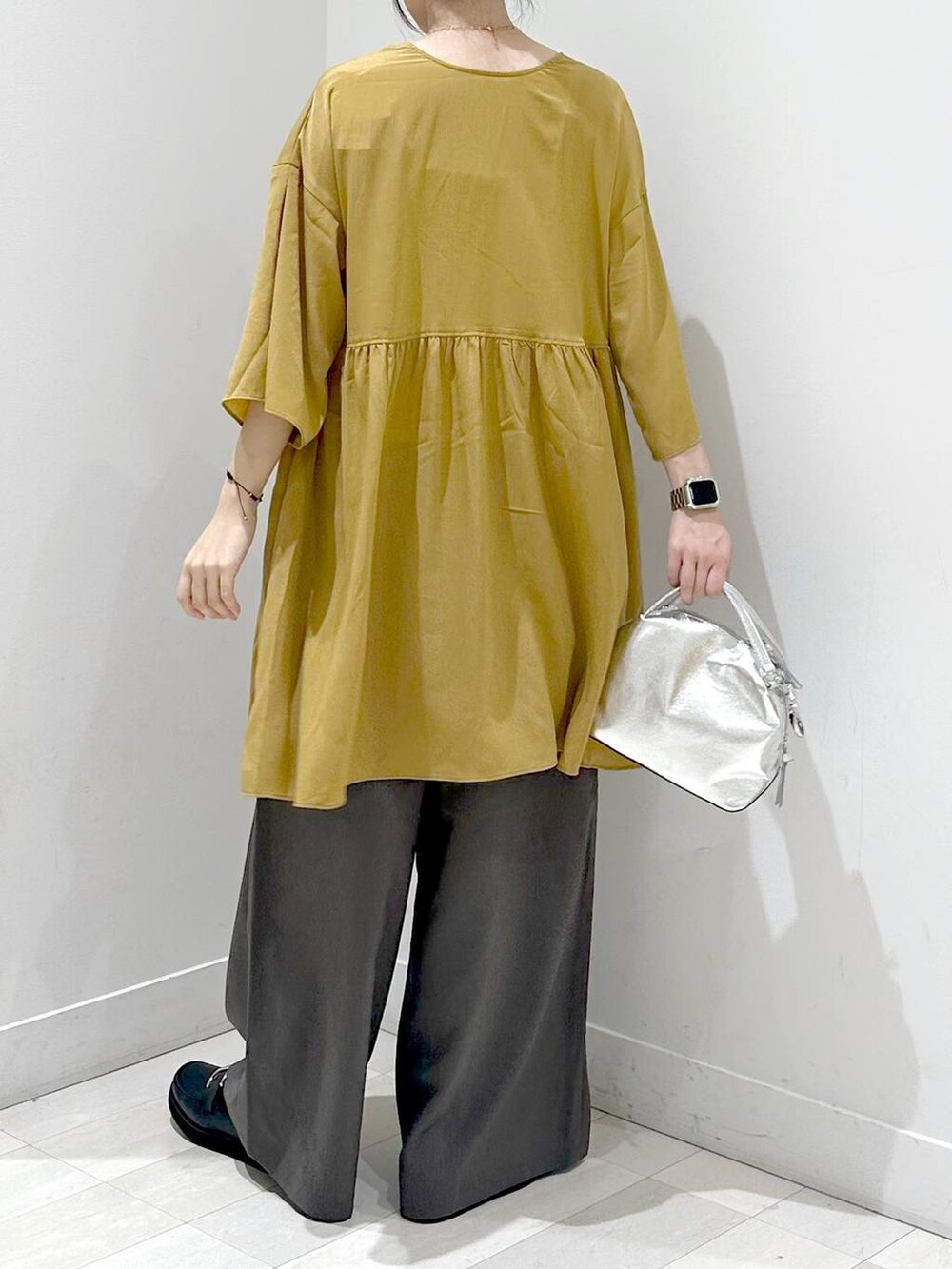 シルバー系のショルダーバッグ、ブラック系のローファー、ホワイト系のキャミソールを着用したレディースの秋コーディネートの3枚目の写真